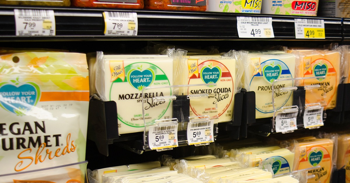 slices of cheese in the dairy aisle of a grocery store displayed using a pusher tray merchandising system